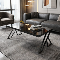 Table basse élégante noire brillante avec pieds en métal en forme de X géométrique pour un intérieur de bureau exécutif contemporain