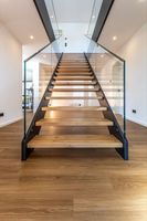 Escalier droit à double poutre avec monte-escalier ouvert, balustrade en verre et marches en bois pour l'intérieur d'une villa