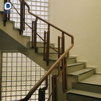 Escalier en L vintage personnalisé Prima en pierre noire avec main courante en bois foncé et balustres en fer ornés de laiton pour manoir classique