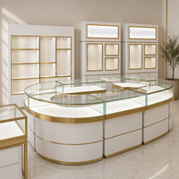 Ensemble de mobilier de boutique de bijoux de luxe sur mesure avec comptoir îlot en verre incurvé, armoires murales rétroéclairées par LED et étagères de présentation