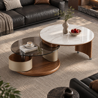 Ensemble de table basse ronde en pierre frittée avec plateau en verre trempé foncé et pieds cintrés sur roulettes pour un salon moderne