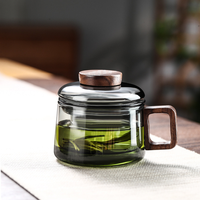 Tasse à thé en verre gris fumé avec poignée en bois et infuseur à couvercle pour la préparation du thé à la maison ou au bureau