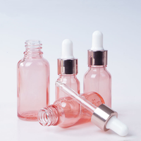 Flacon compte-gouttes en verre rose rechargeable avec bouchon rose doré pour le stockage d'huiles essentielles, de sérums et de produits de soin de la peau