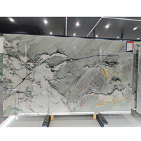Dalle de marbre KT Stone vert clair avec base blanche et veines fluides noires, grises et dorées pour îlot de cuisine de villa de luxe