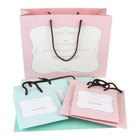 Sacs fourre-tout élégants classiques en papier cartonné blanc rayé avec poignées à cordon, impression offset, biodégradables et recyclables pour boutiques