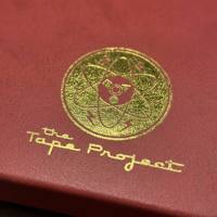 Caja de Regalo Magnética Personalizada con Aspecto de Cuero Borgoña, Logotipo Atómico en Lámina Dorada y Ventana Circular, Empaque de Lujo