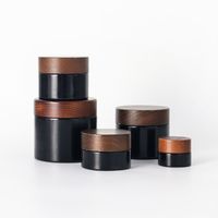 Nuevo frasco de vidrio redondo oscuro con tapa de abeto y dosificador, con bomba para loción, serigrafía y logotipo personalizado, para set cosmético y cuidado de la piel.