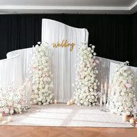 Support de toile de fond en métal irrégulier en forme de vague en S pour décoration de scène de mariage en extérieur sur pelouse