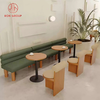 Ensemble de mobilier de restaurant commercial moderne avec tables rondes en bois brun, chaises en bois, banquette en cuir vert pour café