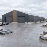 Grand entrepôt et atelier en acier pour le stockage de matériaux de construction avec portes larges et revêtement isolant durable