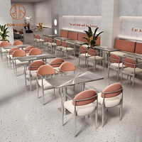 Café à manger ensemble de meubles de café chaises à structure en métal argenté avec siège blanc et dossiers orange avec tables en acier inoxydable