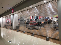 Portes à persiennes transparentes en plastique avec fenêtre visible, portes automatiques à volets, adaptées aux devantures de magasins commerciaux.