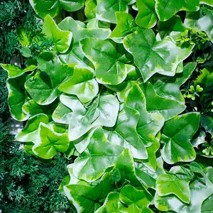 Gramado artificial com parede de fundo verde e flores de plástico para decoração de jardim interno