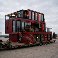 Maison modulaire à deux étages avec balcon en verre et escalier en métal