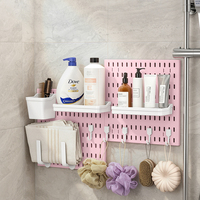 Organisateur mural de salle de bain sans perçage, panneau de rangement en plastique avec crochets et paniers pour articles de toilette et serviettes.