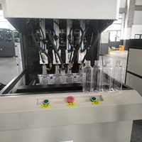 Máquina de soplado de botellas de plástico PET semiautomática de 4 cavidades 250ml-2L de capacidad Dispositivo de moldeo por soplado y estiramiento Bomba de núcleo Motor PLC