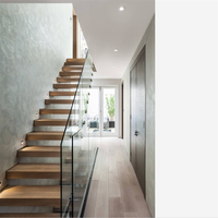 Escalier flottant minimaliste avec marches en bois et balustrade en panneaux de verre transparent