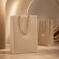 Sac cadeau en papier beige de luxe personnalisé avec poignées en corde pour vêtements, parfums, accessoires de mode et vente au détail en boutique