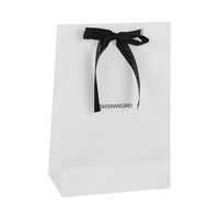Sac à bijoux en carton satiné blanc ivoire avec ruban noir brillant, emballage cadeau minimaliste à contraste élevé pour la vente au détail