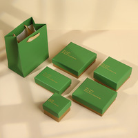 Série d'emballages de bijoux sophistiqués A1 avec couvercles de boîtes vert et blanc, couches de base marron et noires, texte personnalisé et sac de transport