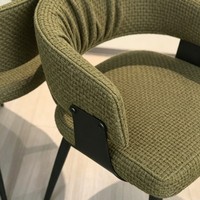 Chaise de salle à manger en bouclette vert mousse, dossier ouvert, accoudoirs incurvés, pieds en métal noir pour hôtel, restaurant, café, usage commercial