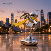 Sculpture d'art métallique en acier inoxydable poli miroir, représentant un lapin de dessin animé tenant un ballon cœur rouge, pour monument de place publique, fabrication sur mesure