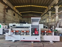 Machine industrielle automatique de rainurage et de chantournage pour cadres de portes, pour la fabrication en série de montants et de garnitures intégrés