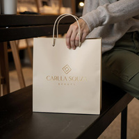 Sac cadeau en papier blanc mat personnalisé avec poignée en ruban satiné, logo or rose pour l'emballage des cliniques de beauté et des salons