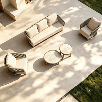 Ensemble de canapé modulaire DWOO en aluminium avec accoudoirs incurvés et table ronde assortie pour l'aménagement de salons extérieurs en resort