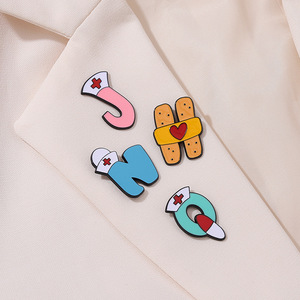 Bán Buôn 26 Thư Tiếng Anh Styling Mềm Men Pins Y Tế Sáng Tạo Ống Nghe Band-Aid Corsage Sắt Kim Loại Lưu Niệm Dập - Product Image 5