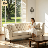 Sofa Tiga Dudukan Chesterfield Kulit PU Warna Krem Beige dengan Sandaran Berumbai Motif Berlian, Hiasan Paku, dan Lengan Bergulung untuk Area Resepsi Hotel