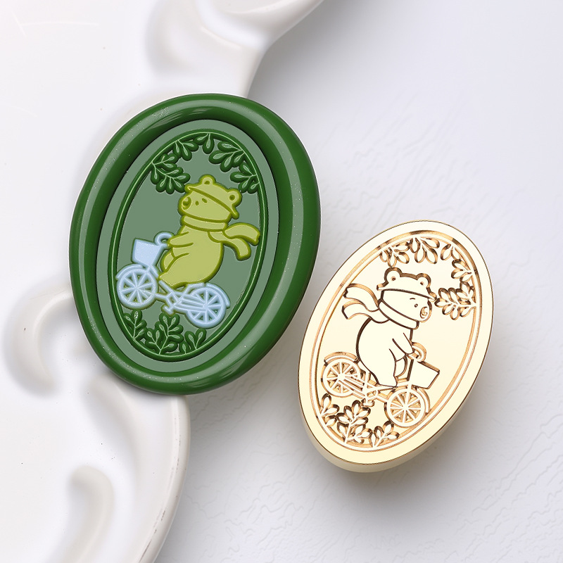 Ours faisant du vélo (forme ovale plate, 2*3cm)