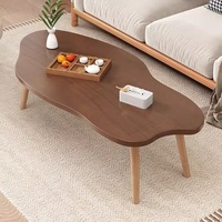 Table basse moderne et simple avec pieds en bois massif et plateau en panneau de densité, forme irrégulière, idéale pour les petits appartements et salons.