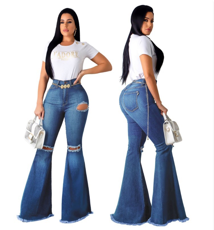 Pantalones vaqueros acampanados azul oscuro desgastados con roturas.