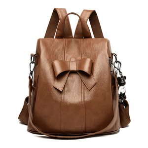 Mochila de cuero suave con diseño de lazo, convertible en bolso cruzado para damas, ideal para el día a día con un lindo colgante. - Product Image 1