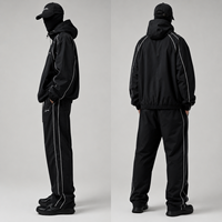 Ensemble de survêtement coupe-vent personnalisé pour homme en nylon noir, veste à capuche et pantalon large avec passepoil blanc, style streetwear et sportif