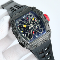 Montre mécanique à tourbillon intégré avec boîtier en forme de barillet en fibre de carbone, bracelet en caoutchouc et fond transparent.