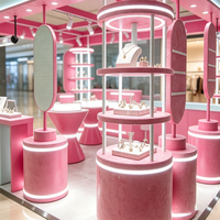 Kiosque de bijouterie rose pastel et menthe, stand modulaire avec présentoirs cylindriques éclairés par LED
