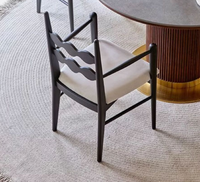 Fauteuil de salle à manger en bois massif noir avec dossier ondulé et coussin en cuir blanc, design moderne pour la maison