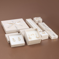Caja de regalo de joyería de Navidad pequeña directa de fábrica Paquete de joyería 2023 con nodo Debossed logo cinta Lazo y esponja