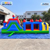 Structure gonflable commerciale avec parcours d'obstacles, double toboggan de course et obstacles d'escalade, idéale pour le jeu en extérieur