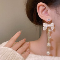 Boucles d'oreilles pendantes en alliage plaqué or avec perle d'eau douce blanche, nœud papillon et pompon – Meilleure vente