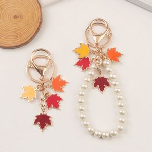 จี้รูปใบเมเปิ้ลเคลือบทองดีไซน์ใหม่พร้อมไข่มุก  พร้อมส่ง  พวงกุญแจโลหะเคลือบลายพืช - Product Image 1
