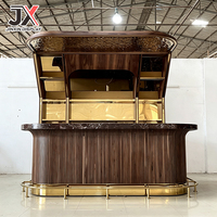 Comptoir de bar incurvé sur mesure de qualité supérieure, panneau en bois de noyer cannelé, dessus en marbre foncé, repose-pieds en laiton, éclairage LED, mobilier pour club et restaurant