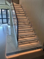 Escalier droit moderne d'intérieur à double poutre latérale avec garde-corps en verre trempé, acier galvanisé, marbre, métal, granit