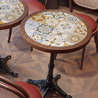 Table carrée à motifs style bohème, fauteuil en noyer massif avec coussin vert et dossier floral, petite suite de salon pour café