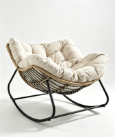Fauteuil à bascule moderne en rotin tressé, capitonné avec boutons, coussin épais beige, structure en métal noir, coque incurvée surdimensionnée pour salon