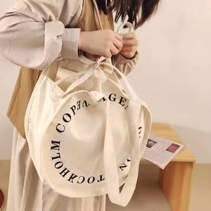กระเป๋าผ้าแคนวาสสีเบจขายส่ง รีไซเคิลได้ ใช้ใส่ของชำ ของชายหาด พิมพ์ลายตัวอักษร โลโก้ตามสั่ง หูหิ้วคู่ แฟชั่นทันสมัย - Product Image 2