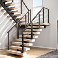 Escalier en bois à poutre centrale unique avec garde-corps en câble d'acier carbone noir et marches en bois massif pour villa intérieure