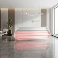 Bureau de réception personnalisé au design moderne en pierre Corian blanche avec décoration LED pour salon de beauté